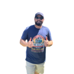 Man in a blue Junk Seekers t-shirt giving thumbs up, representing local expertise and personalized service for property cleanout and junk removal in San Diego.
