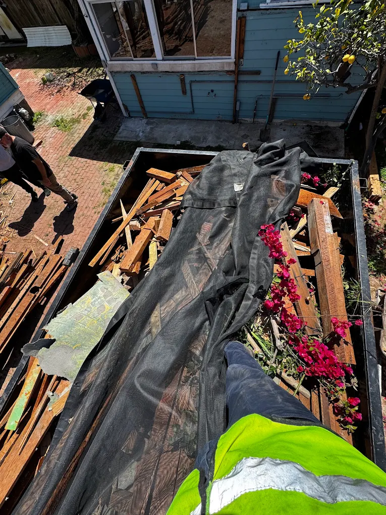 construction debris trailer rental at job site in San Diego with crew loading debris